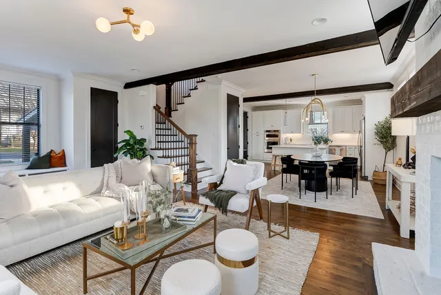 a living room with furniture a dining table and a chandelier