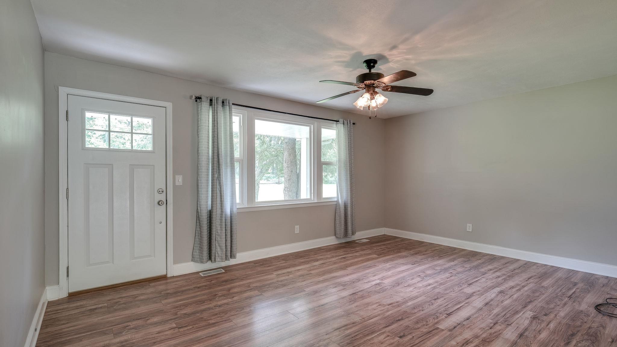 7373 Harper Road Joelton, TN 37080 - Photo 7 of 30 The living room is expansive with large windows for natural sunlight and the flooring is a high quality laminate for country living durability~