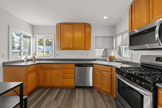 a kitchen with stainless steel appliances a stove a sink and a microwave