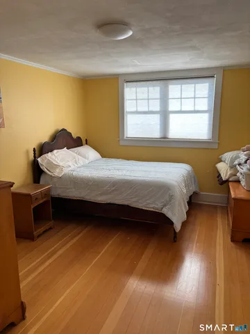 a bedroom with a bed and wooden floor