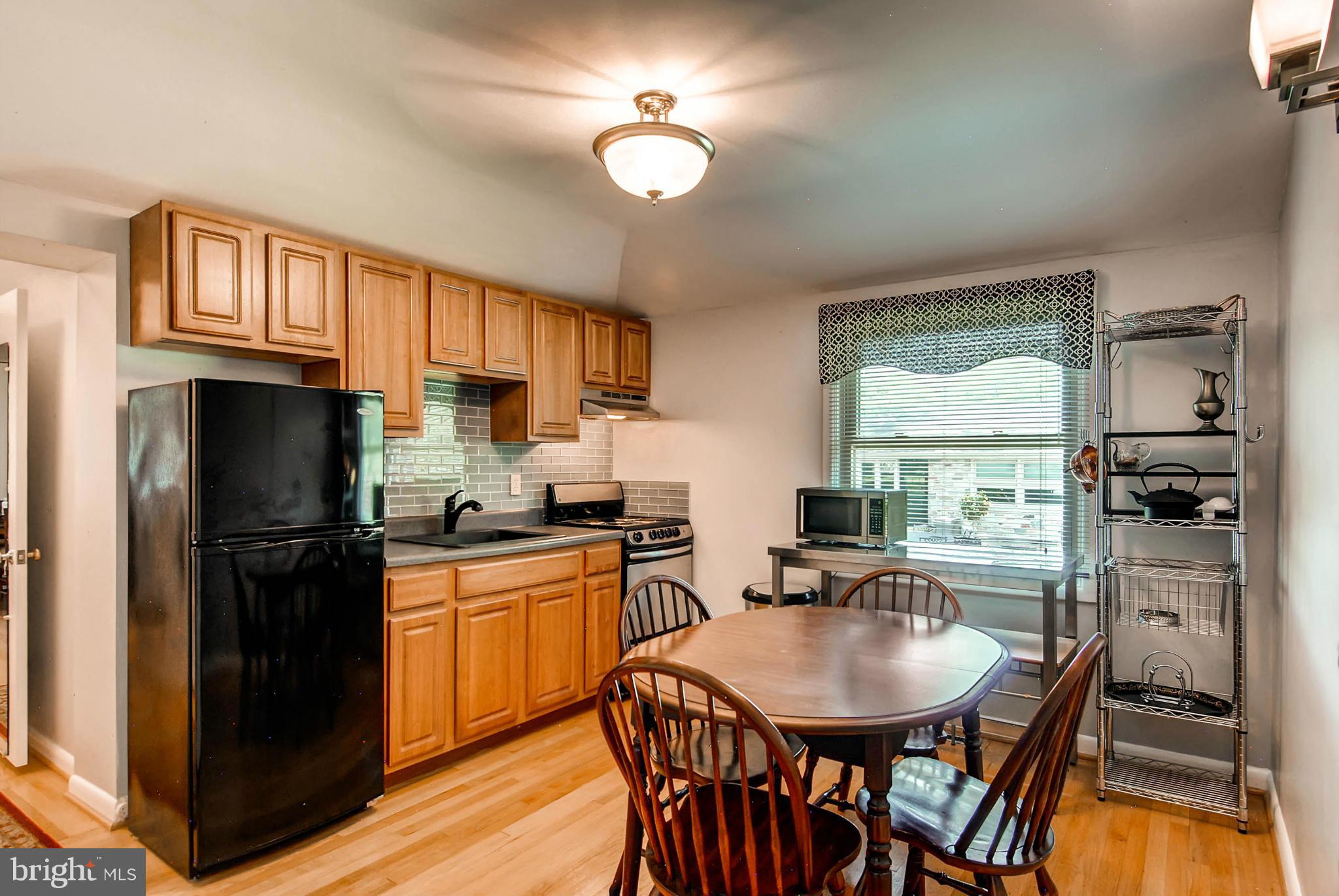1202 Windy Gate Road Towson, MD 21286 - Photo 11 of 29 a kitchen with a table chairs refrigerator and microwave