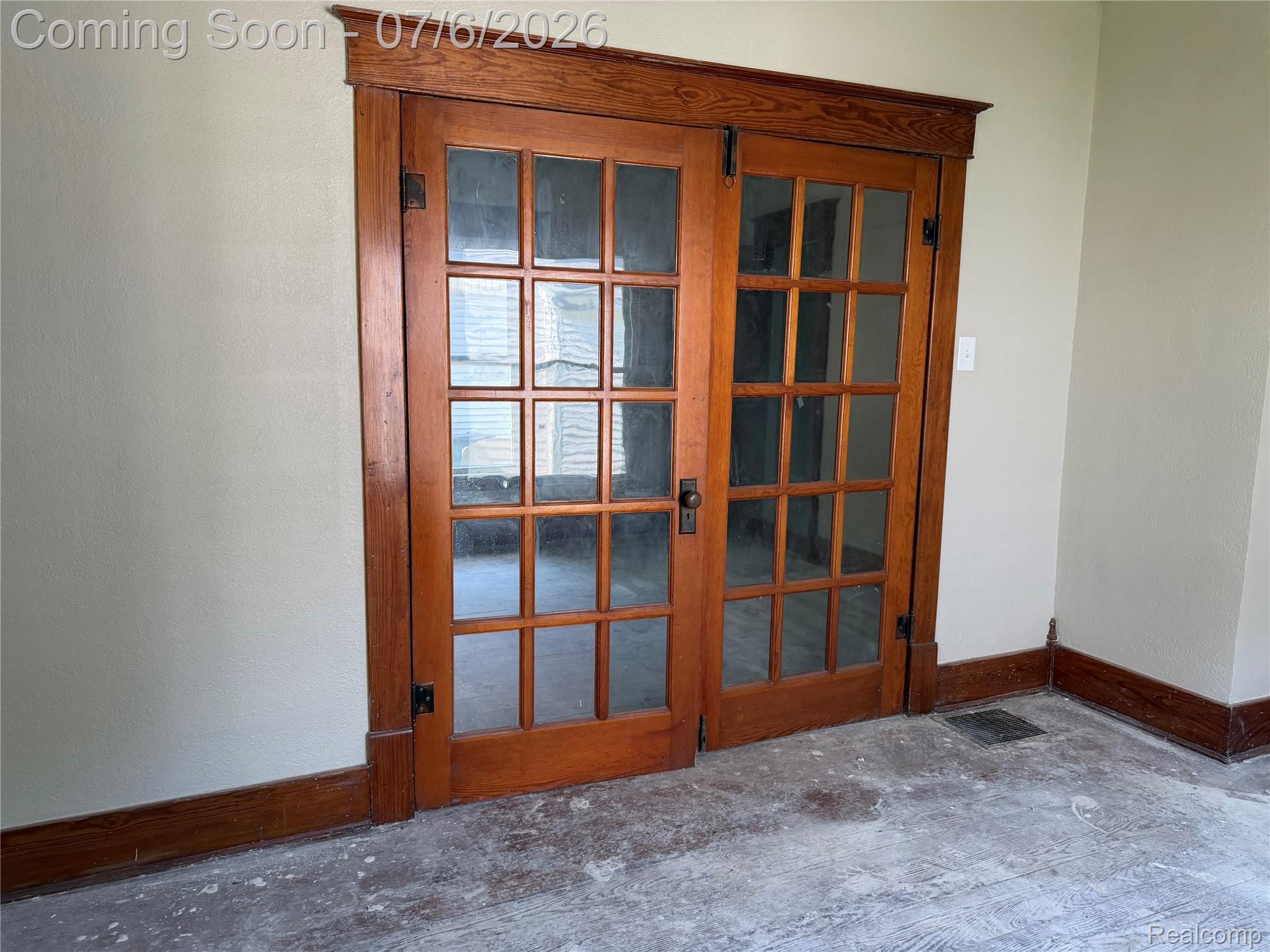 808 Division Street Owosso, MI 48867 - Photo 8 of 25 French doors with mullioned glass panels and rich wood-finish trim, complemented by matching baseboards