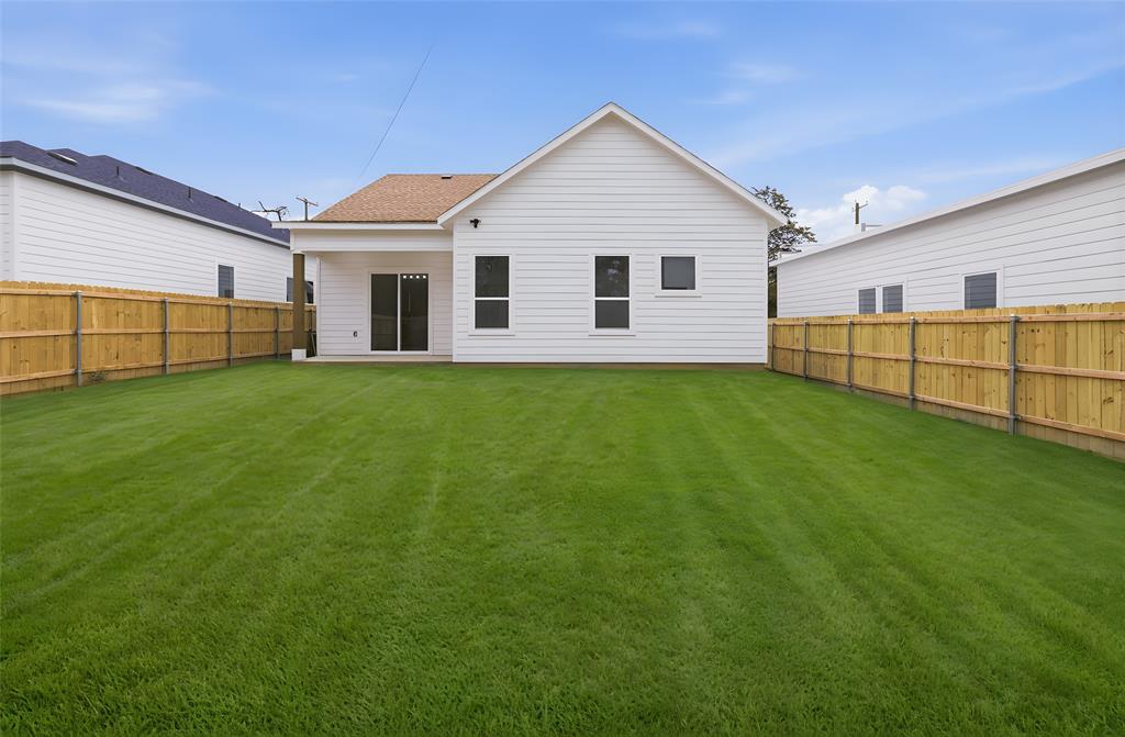 1119 Riverwood Road Dallas, TX 75217 - Photo 29 of 32 Back of house featuring a fenced backyard and a shingled roof