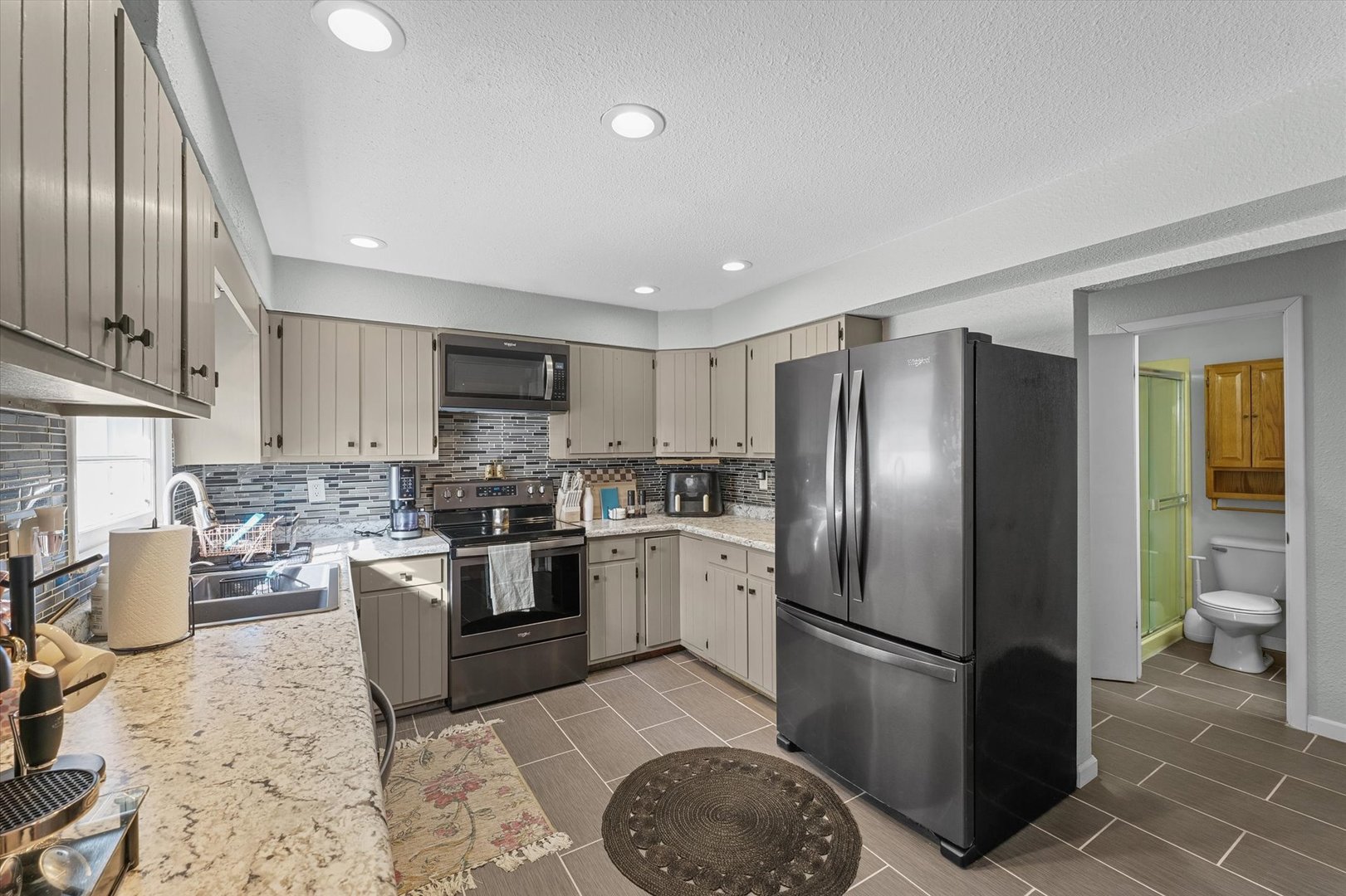 1609 West John Street Champaign, IL 61821 - Photo 12 of 30 a kitchen with stainless steel appliances granite countertop a refrigerator a stove a sink and a microwave