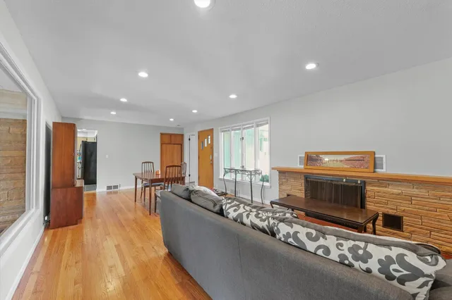 a living room with stainless steel appliances furniture a rug and a flat screen tv