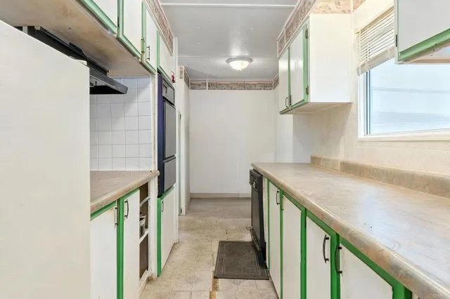 a kitchen with a sink a refrigerator and window