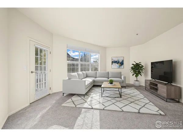 a living room with furniture a flat screen tv and a window