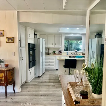 a kitchen with stainless steel appliances kitchen island granite countertop a refrigerator and a sink