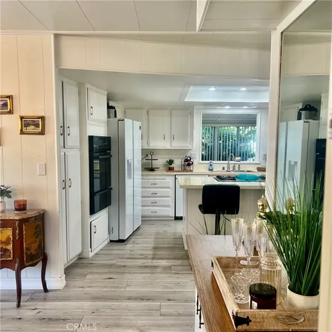 a kitchen with stainless steel appliances kitchen island granite countertop a refrigerator and a sink