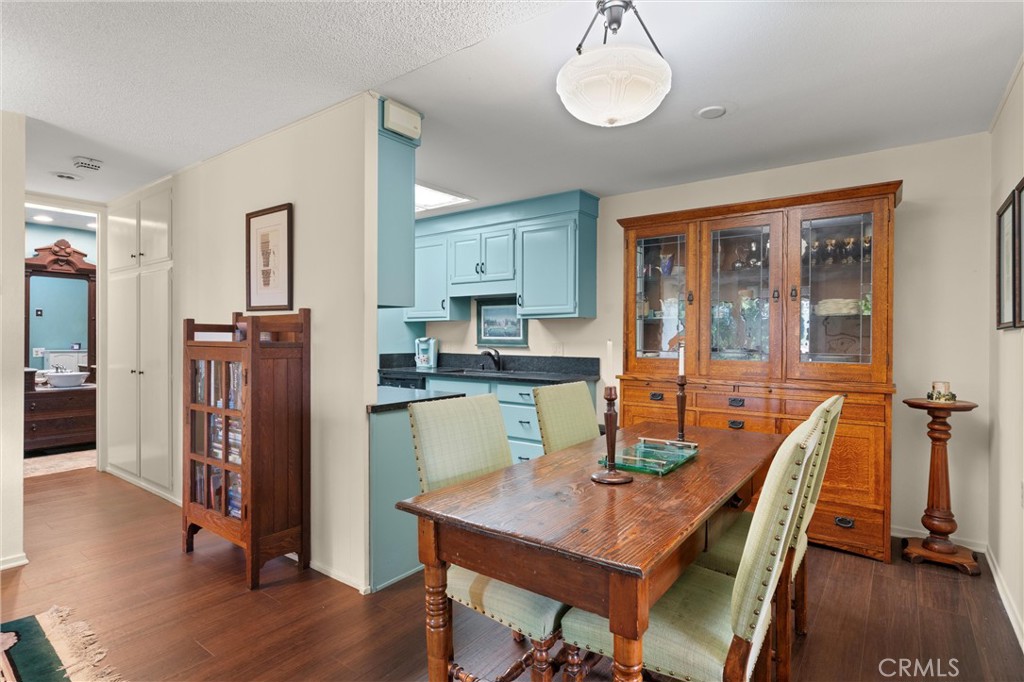 2121 Ronda Granada, Unit N Laguna Woods, CA 92637 - Photo 13 of 38 a kitchen with stainless steel appliances granite countertop a refrigerator a stove top oven a dining table and chairs with wooden floor