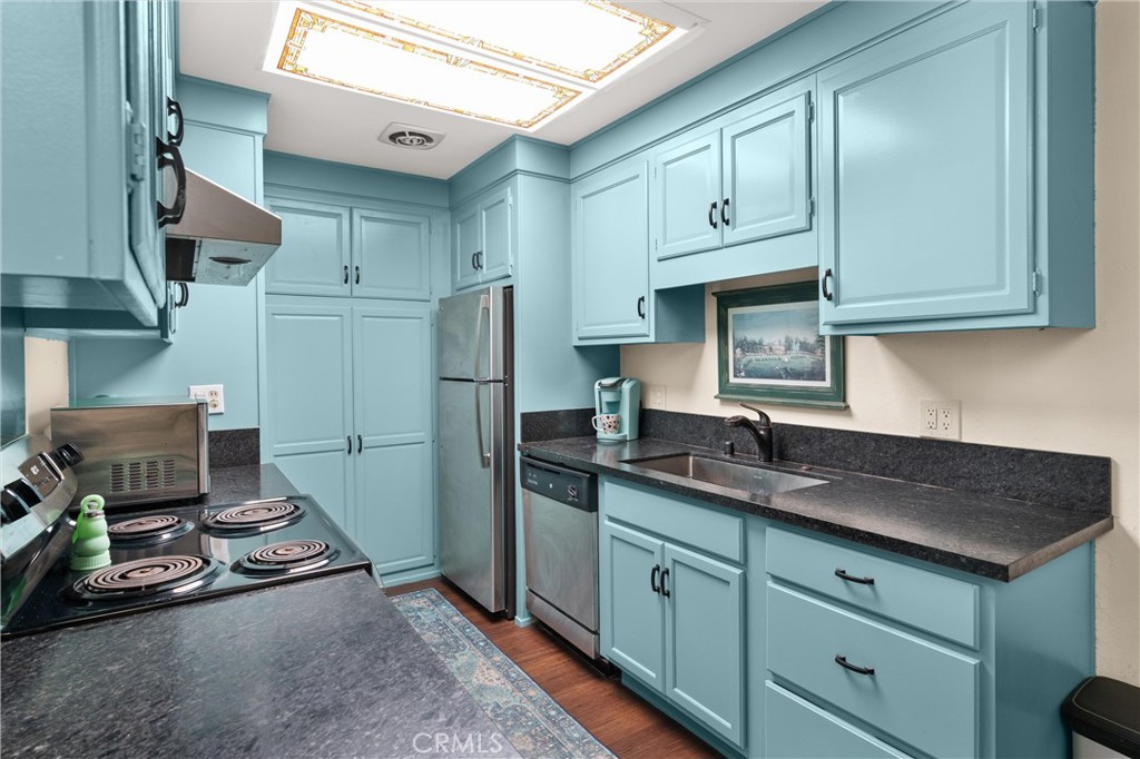 2121 Ronda Granada, Unit N Laguna Woods, CA 92637 - Photo 16 of 38 a kitchen with stainless steel appliances granite countertop a sink stove and refrigerator