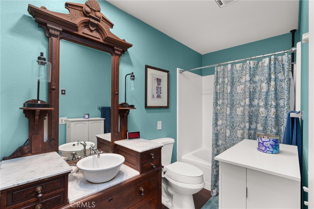 2121 Ronda Granada, Unit N Laguna Woods, CA 92637 - Photo 19 of 38 a bathroom with a granite countertop sink a toilet and a mirror