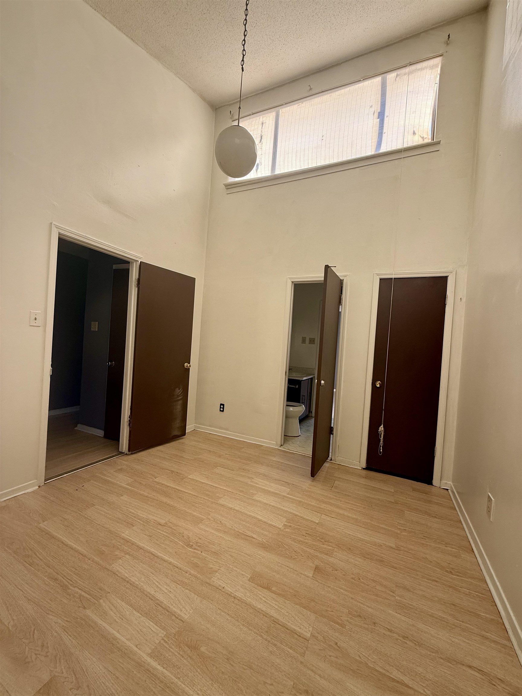 3091 Range Line Road Memphis, TN 38127 - Photo 12 of 13 Empty room with a high ceiling, a textured ceiling, and light wood-style floors