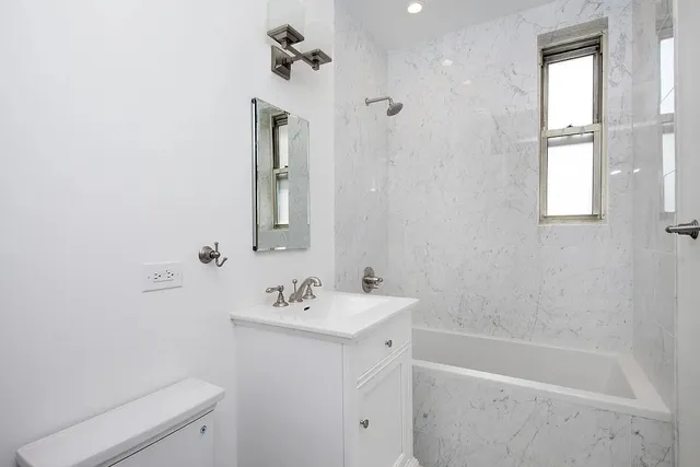 a bathroom with a sink a toilet and shower