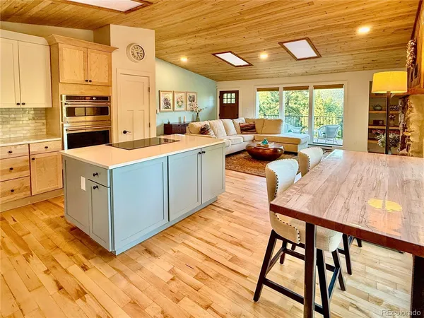 a view of a kitchen with kitchen island a large window a sink and counter space