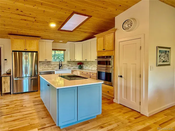 a kitchen with stainless steel appliances granite countertop a refrigerator a sink dishwasher a stove and a refrigerator with wooden floor