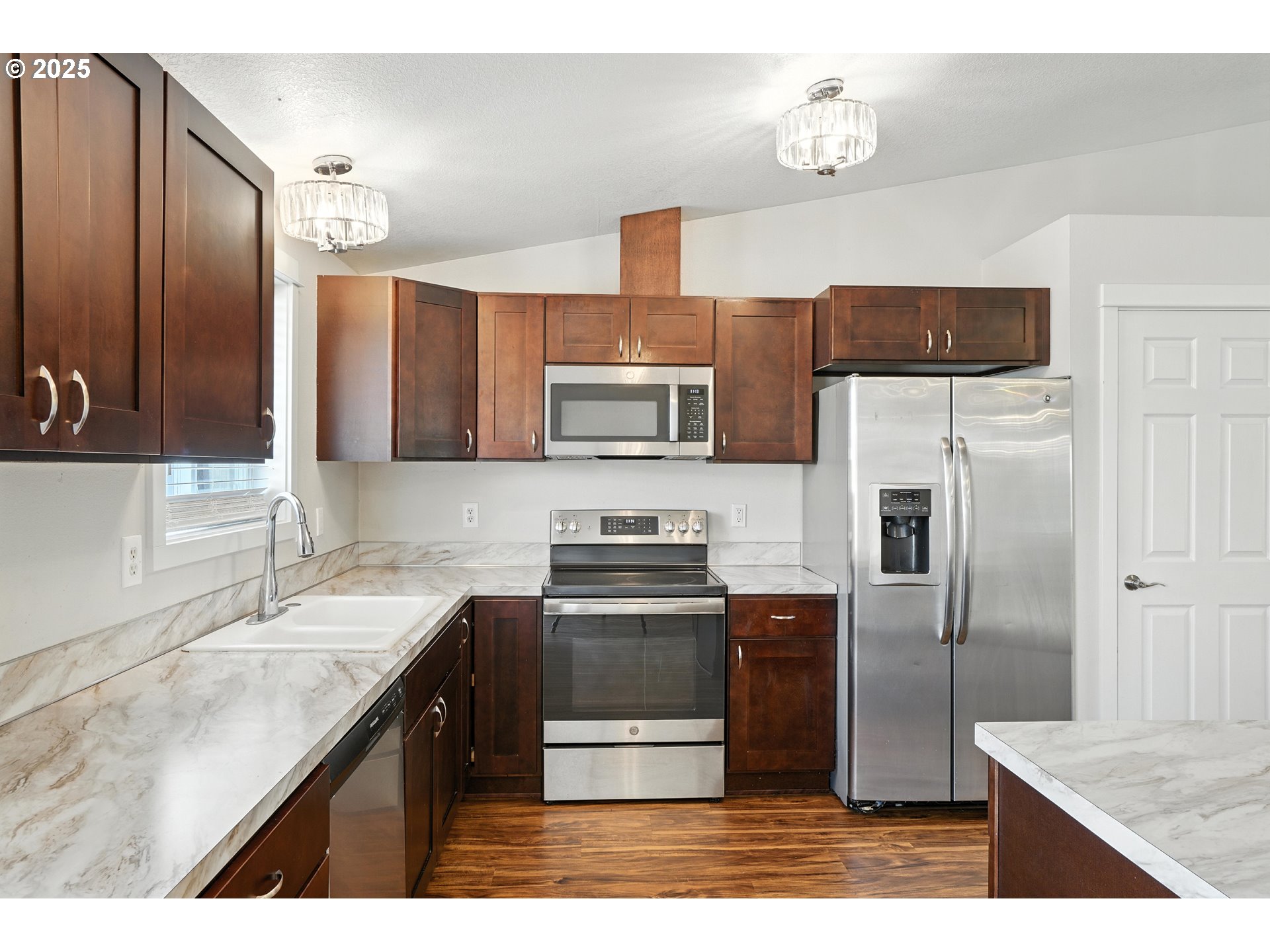 1608 Northwest 3rd Street Battle Ground, WA 98604 - Photo 10 of 26 a kitchen with stainless steel appliances a sink and a refrigerator