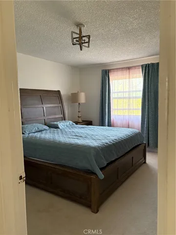 a bedroom with wooden floor and flat screen tv