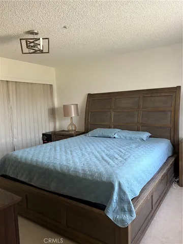a bedroom with a bed and potted plant on the table