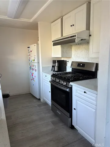 a kitchen with granite countertop a stove and a refrigerator