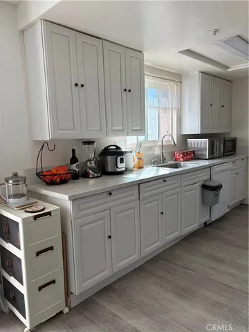 a kitchen with stainless steel appliances white cabinets sink and window