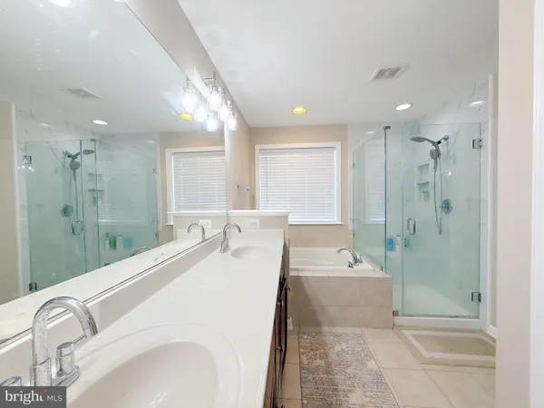 a spacious bathroom with a tub sink and mirror