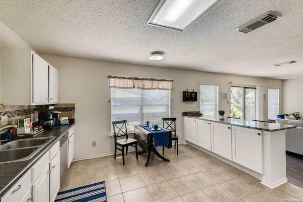a kitchen with sink cabinets and dining table chair