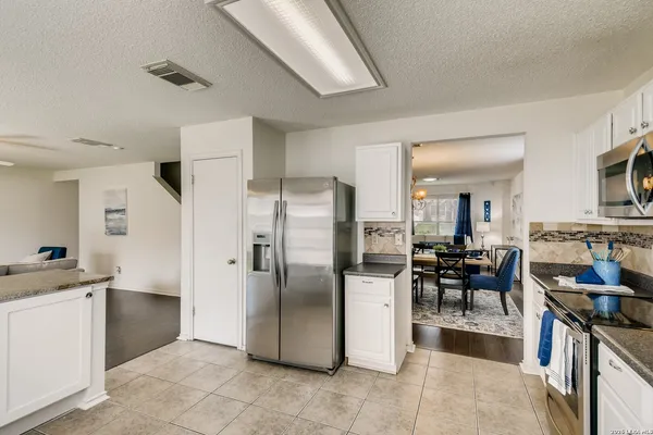 a kitchen with stainless steel appliances granite countertop a refrigerator and a stove