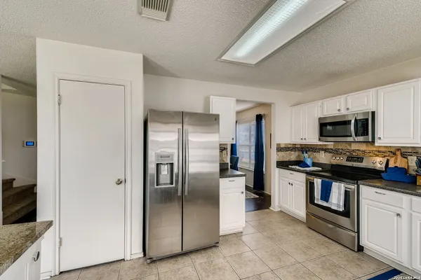 a kitchen with stainless steel appliances granite countertop a refrigerator and a sink