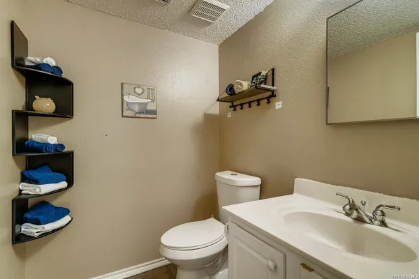 a bathroom with a sink mirror and toilet