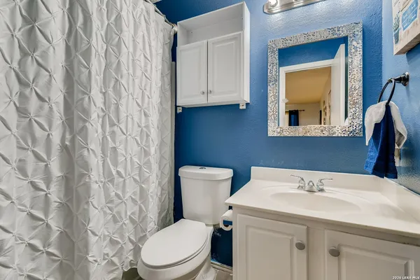 a bathroom with a toilet a sink and a mirror