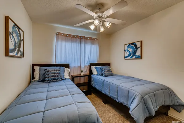a bedroom with two beds and a chandelier