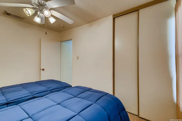 a bedroom with a bed and a chandelier fan