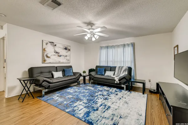a living room with furniture and a flat screen tv with wooden floor