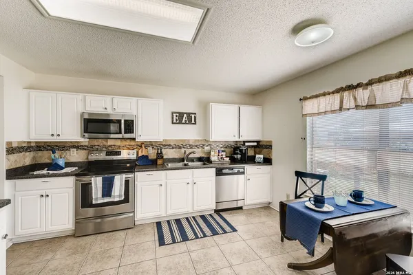 a kitchen with granite countertop a sink stove and cabinets