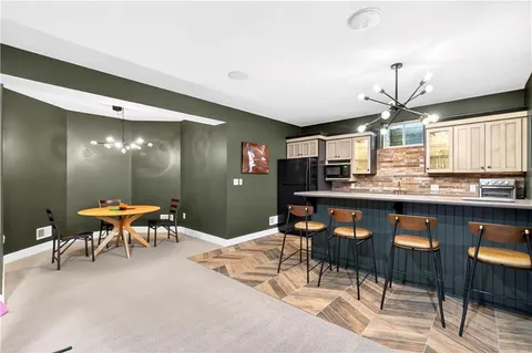 a kitchen with a dining table chairs and white cabinets