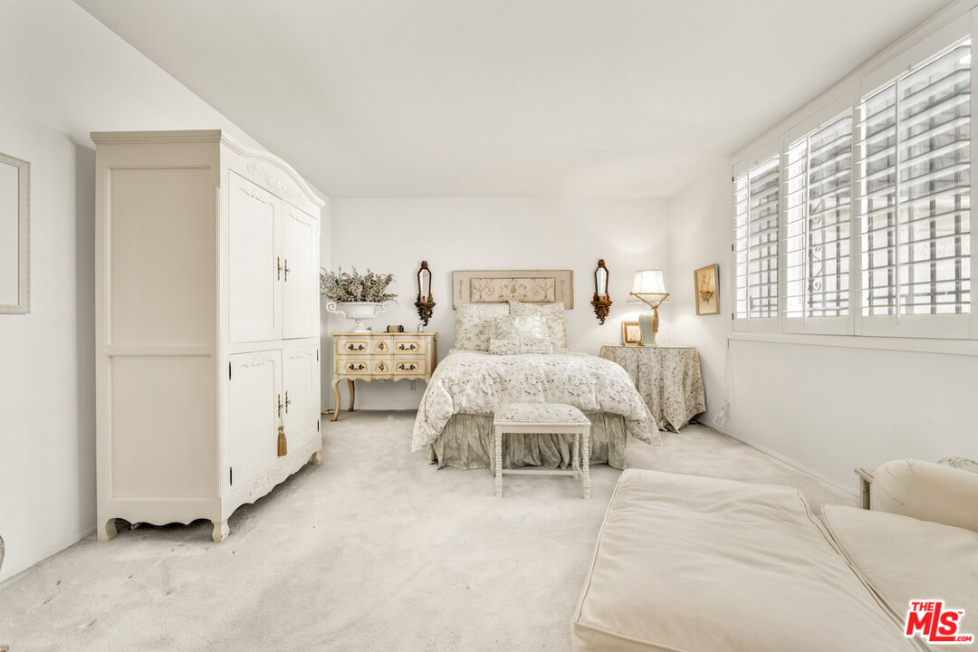 2385 Roscomare Road, Unit D17 Los Angeles, CA 90077 - Photo 11 of 22 a bedroom with a bed white couch and a window