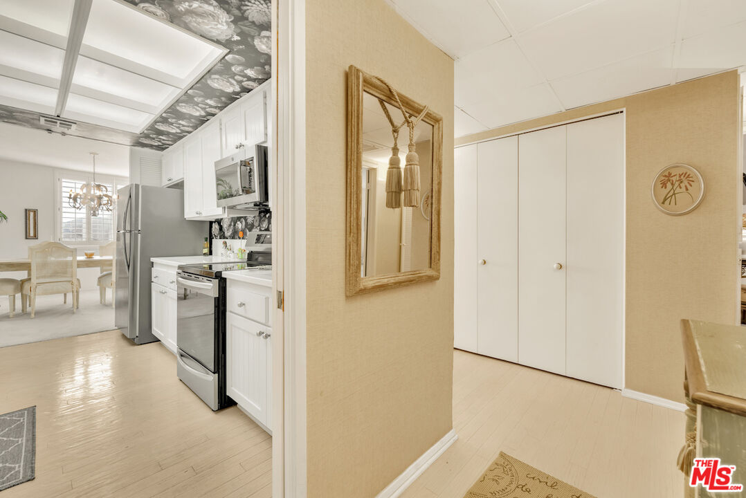 2385 Roscomare Road, Unit D17 Los Angeles, CA 90077 - Photo 3 of 22 a hallway with white cabinets and wooden floor