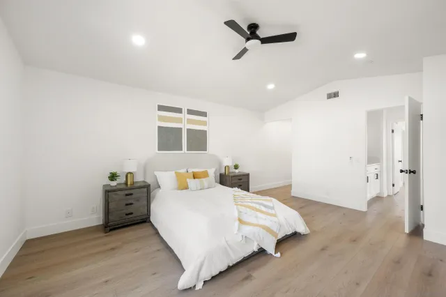 a bed room with a bed and a ceiling fan