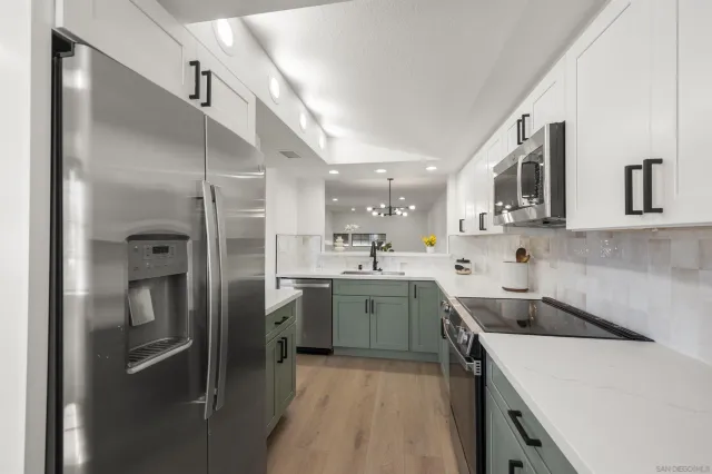 a kitchen with a sink a refrigerator and cabinets
