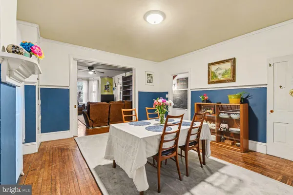a kitchen with granite countertop a white stove top oven and white cabinets with wooden floor