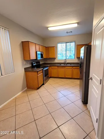 a kitchen with stainless steel appliances granite countertop a refrigerator and a stove