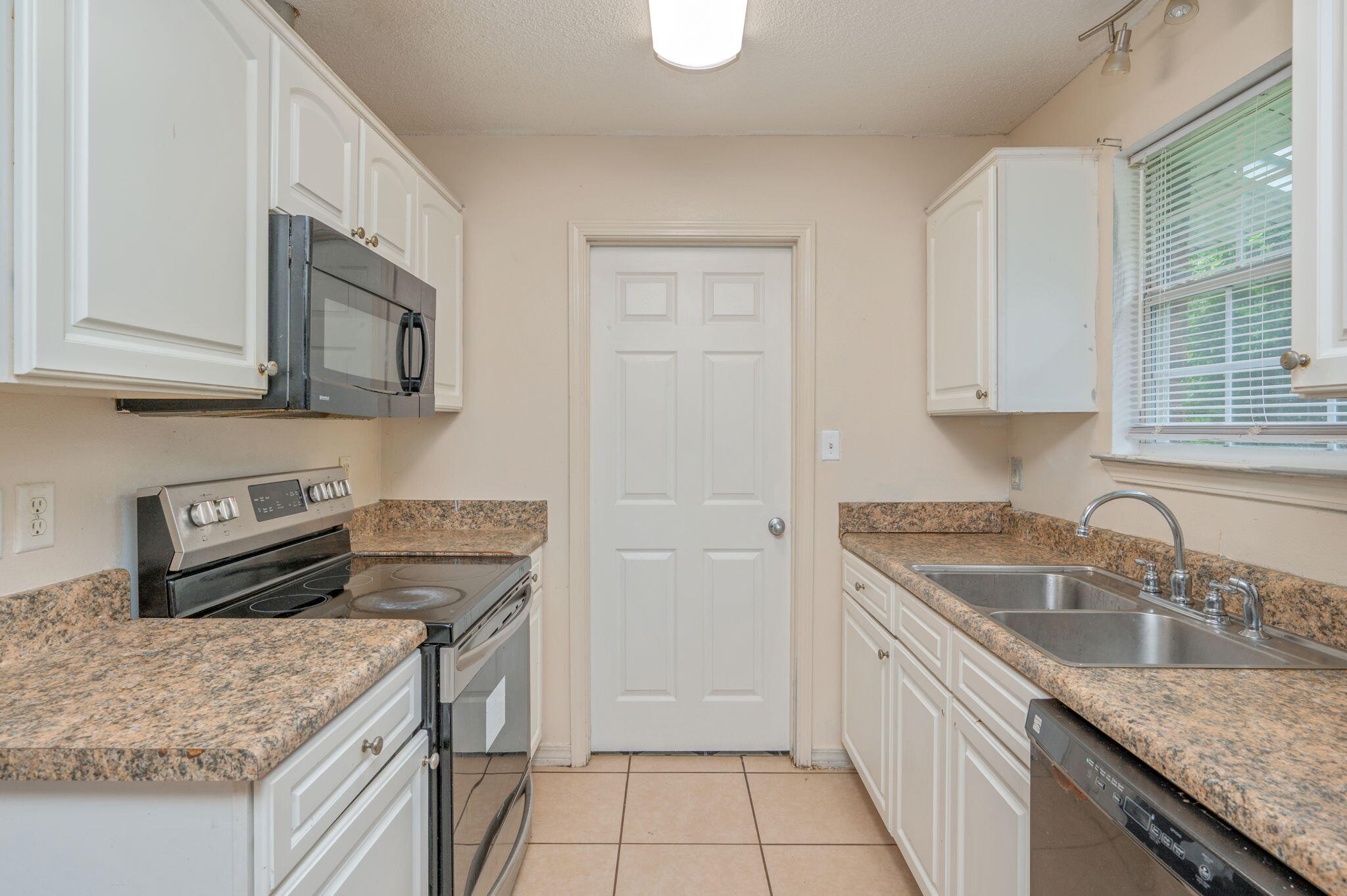 834 McDonald Street Crestview, FL 32536 - Photo 7 of 35 a kitchen with granite countertop a sink stove and cabinets