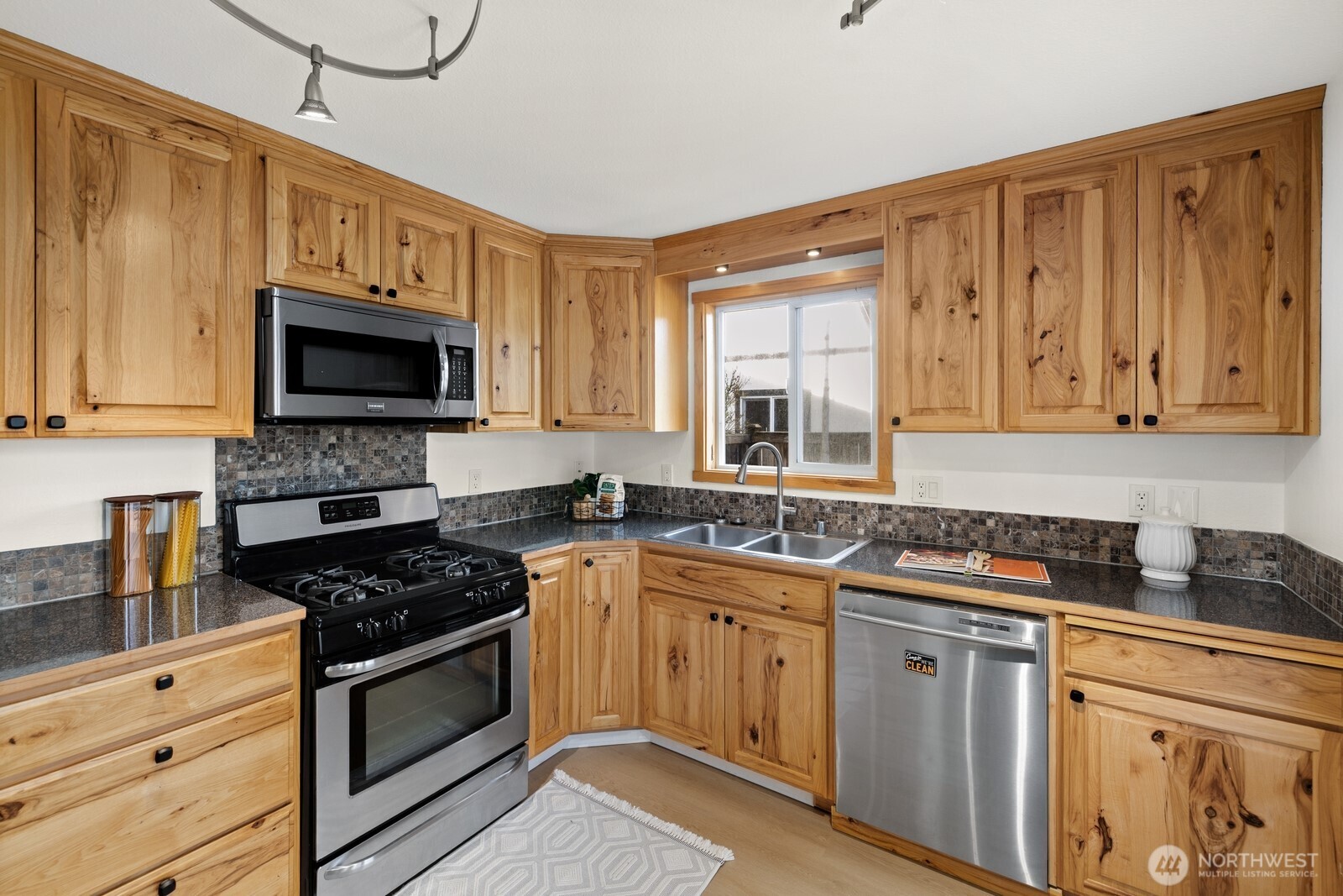 506 Train Street Southeast Orting, WA 98360 - Photo 11 of 24 a kitchen with stainless steel appliances granite countertop a stove a sink and a microwave