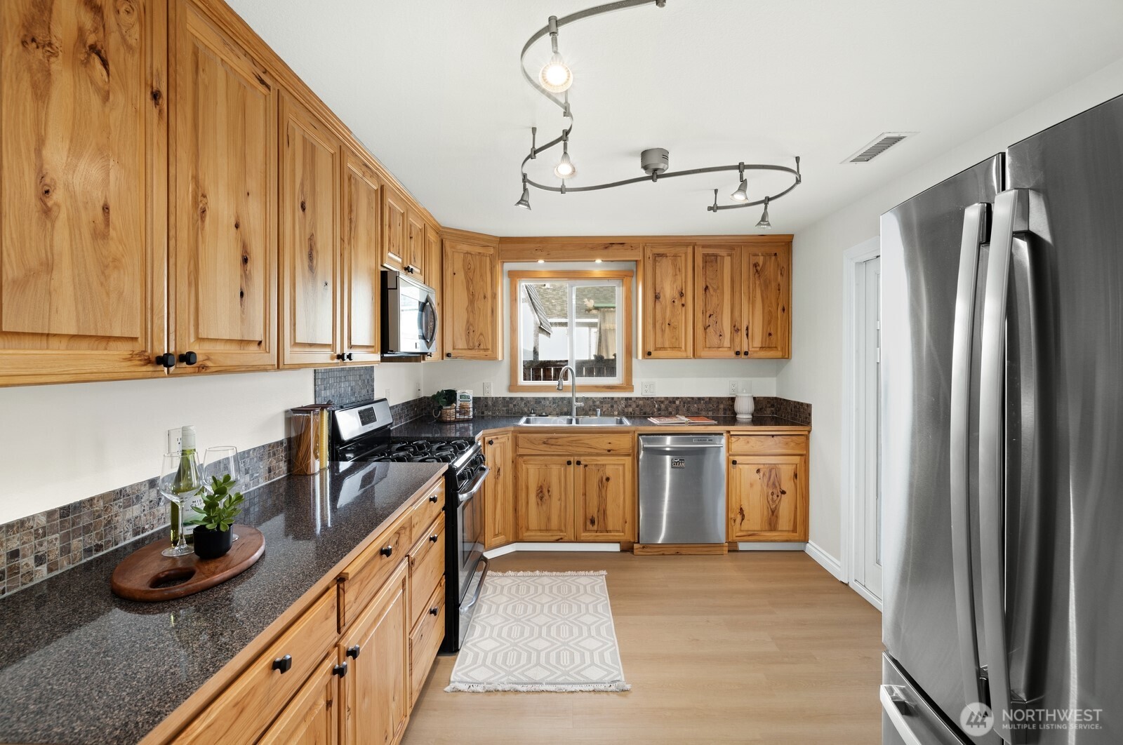506 Train Street Southeast Orting, WA 98360 - Photo 9 of 24 a kitchen with a refrigerator a sink dishwasher stove and oven with wooden floor