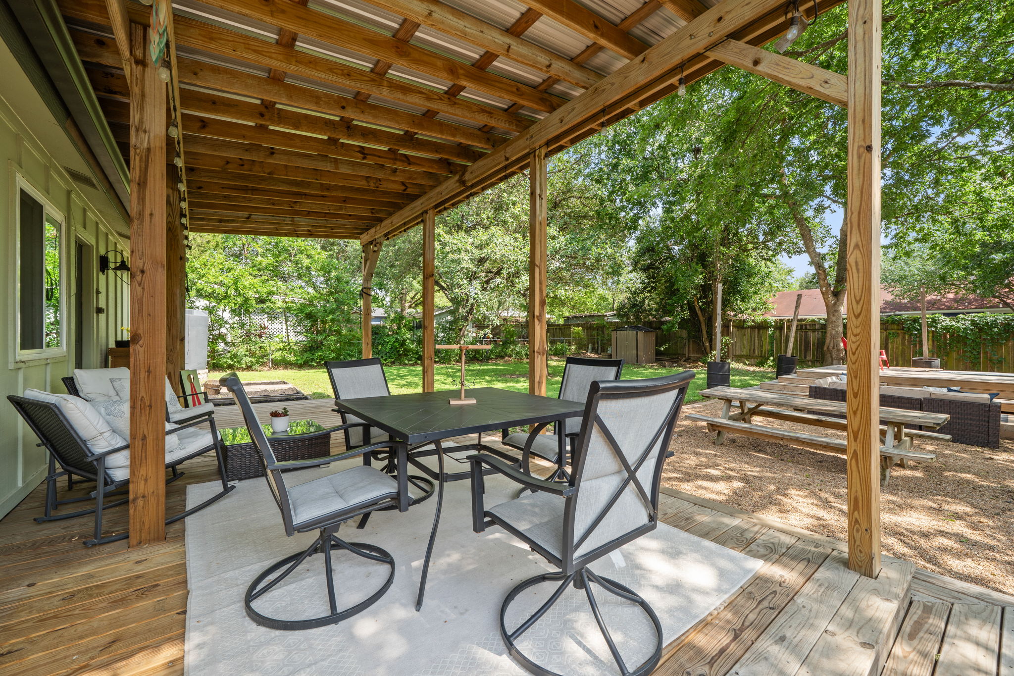 705 Dulwich Street Austin, TX 78748 - Photo 24 of 36 An inviting covered patio with a dining set and outdoor seating overlooks a well-maintained yard.