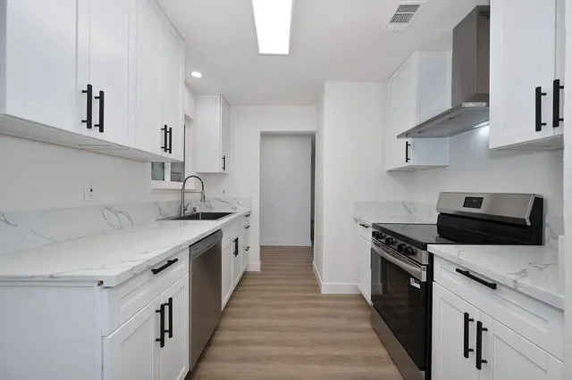 a kitchen with granite countertop a stove and a sink