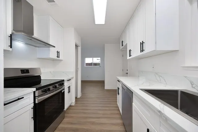 a view of empty room with wooden floor