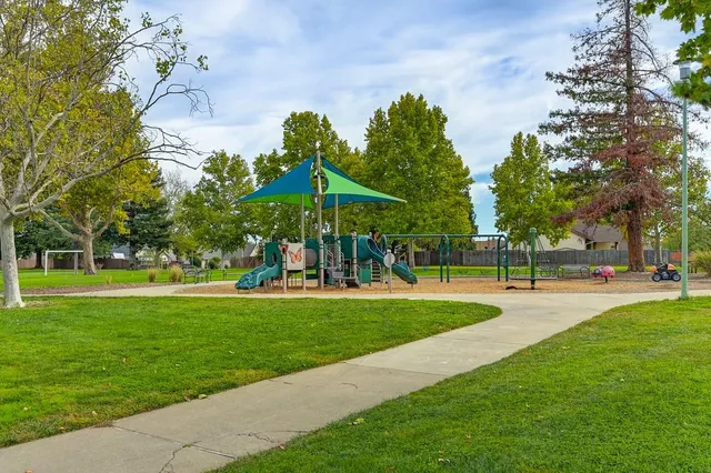 an aerial view of residential houses with outdoor space and trees