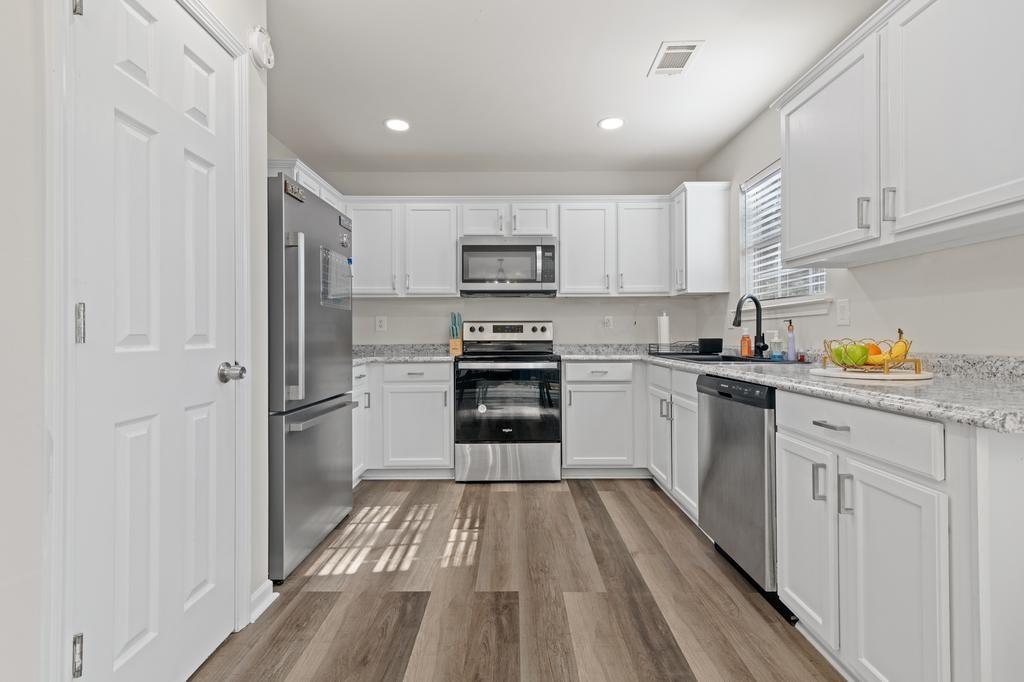 5914 Waggoner Court Rex, GA 30273 - Photo 12 of 21 a kitchen with white cabinets and stainless steel appliances
